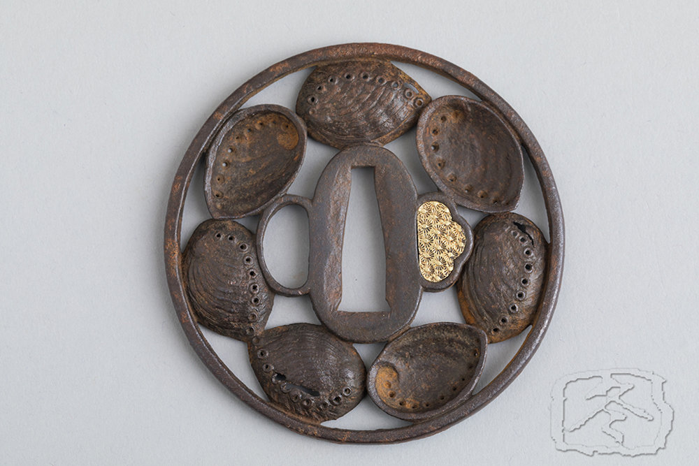 IRON TSUBA 18th/ 19th Century An iron tsuba decorated with seven finely worked abalone shells. With fitted wood box. Unsigned Diametre: 8cm